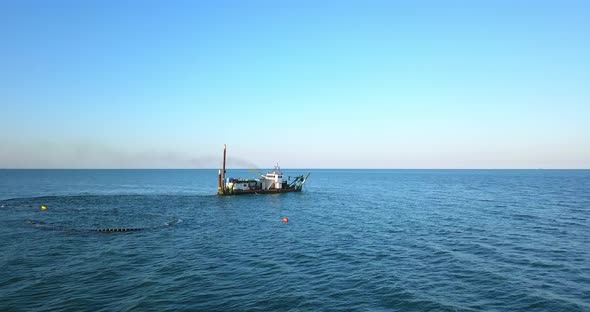 Ship on the Sea is Grating the Sand with the Pipes Under Water