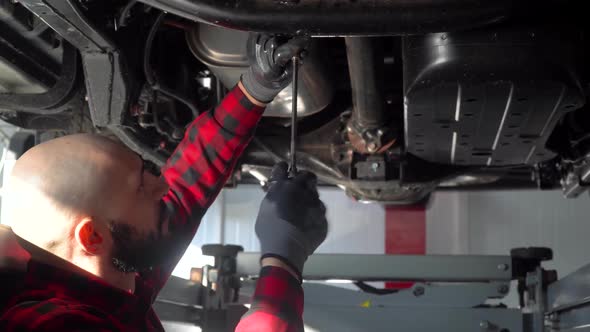 Man Mechanic Repairing a Car in Car Repair Shop. Car Service, Repair and Maintenance