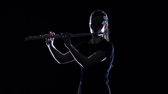 Female Musician Blows Motif in Flute in Slow Motion. Studio