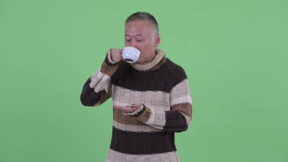 Happy Mature Japanese Man Thinking While Drinking Coffee