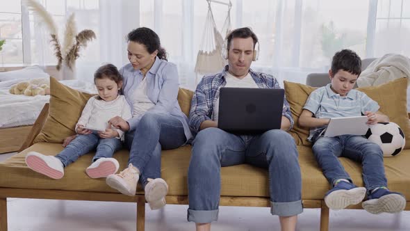 Modern Family with Kids Busy on Gadgets at Home