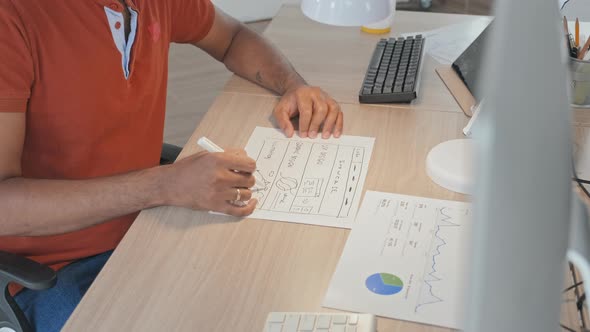 Software Developer Drawing Scheme on Piece of Paper