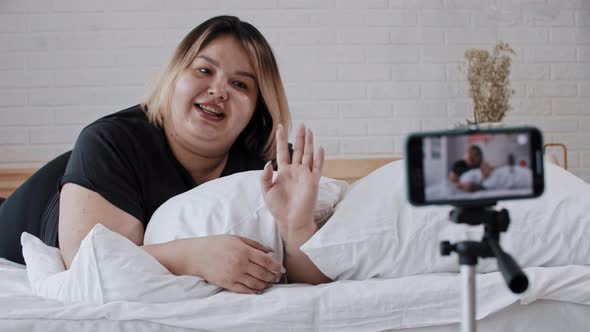 A Confident Overweight Woman Feminist Lying in Bed and Making a Video for Her Followers About Body
