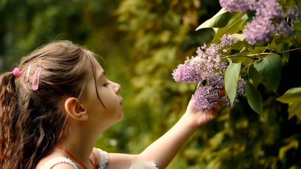 Cute Baby Girl Adorable Little Smelling Flower. Happy Beautiful Kid With Pretty Face Having Fun.