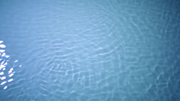 Slo-motion water rippling against blue background