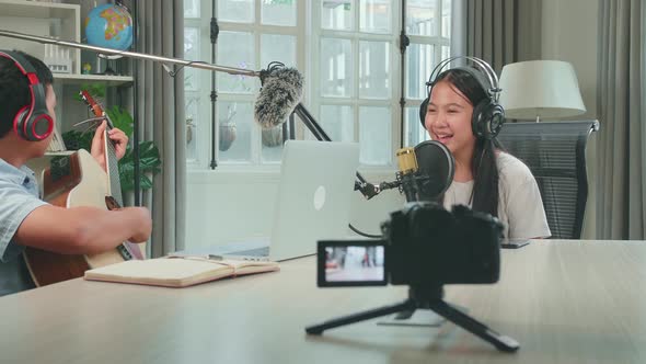 Camera Recording, Asian Kid Girl Singing While Boy Playing The Guitar During Online Livestream