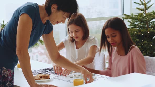 Smiling multiethnic family do jigsaw puzzles