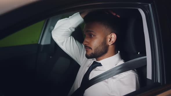 Tired Young Employee Sitting In The Driving Seat Of The Car Wearing Seat Belt