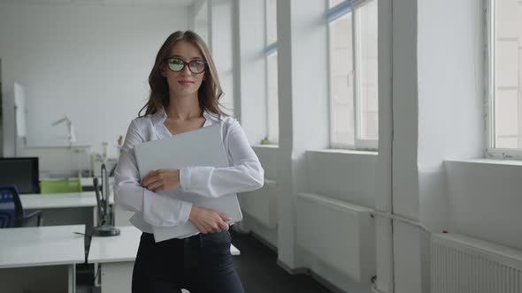 Office Woman Stands and Holds Her Documetns