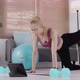 Young Asian woman in sportswear doing exercise and watching fitness tutorial online video on tablet. - VideoHive Item for Sale