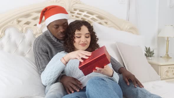 Man Presents New Year's Gift to His Girlfriend While Lying in Bed