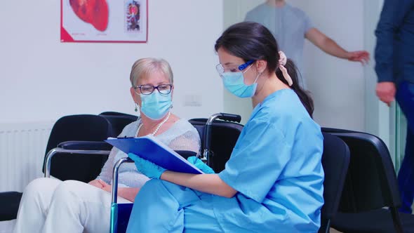 Nurse Explaining Diagnosis To Elderly Disabled Woman