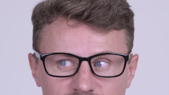 Eyes of Hipster Man Wearing Eyeglasses Against White Background