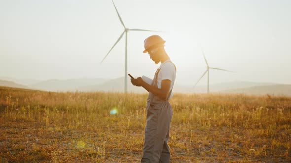 African American Industrial Worker Having Mobile Conversation While Standing on