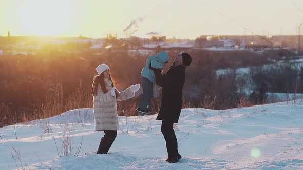 Man in Black Dressing Plays with Child Near Long Haired Lady