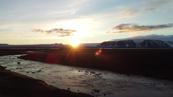 Flying Over Glacier River at Sunset with Text Space