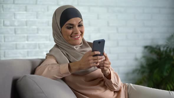 Happy Arab Female Scrolling Social Networks Photo Smartphone, Housewife Leisure