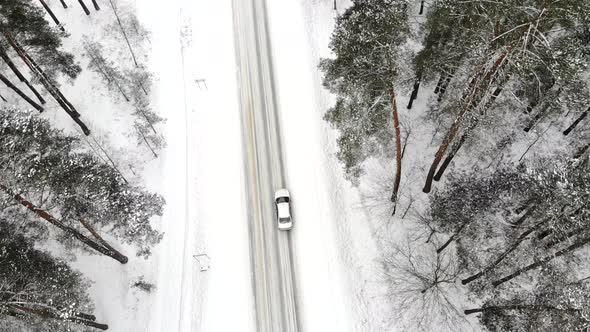 Car on a Winter Road in the Forest Top View