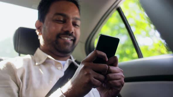Indian Male Passenger with Smartphone in Taxi Car