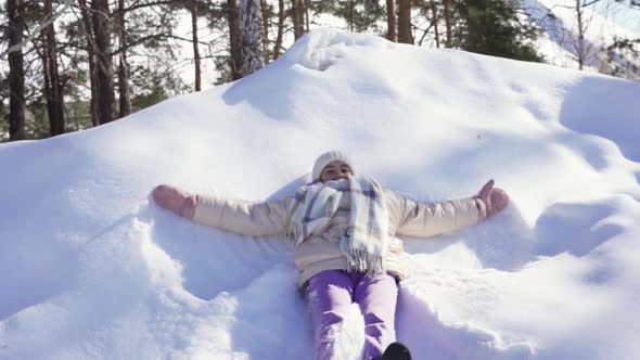 Little Girl Playing with Snow Outdoors in Winter