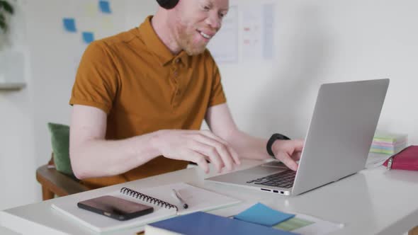 Albino african american man with dreadlocks making video call on the laptop