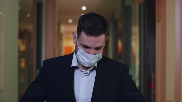 Confident Young Businessman in Suit and Covid Face Mask Posing in Office Corridor