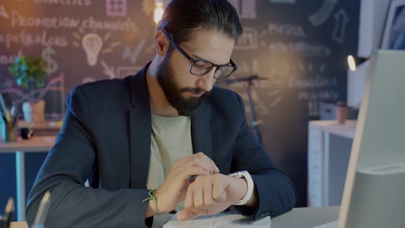 Slow Motion Portrait of Serious Businessman Using Smart Watch Working Late in Office