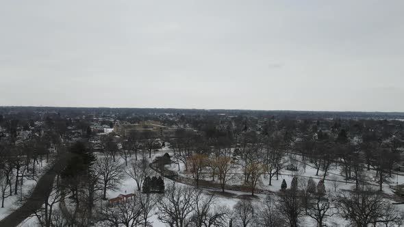 Drone view of snow covered park in center of city. Residential neighborhoods surrounding park.