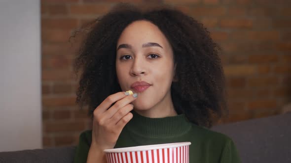 Close Up Portrait of Young African American Woman Watching Movie and Eating Popcorn Slow Motion