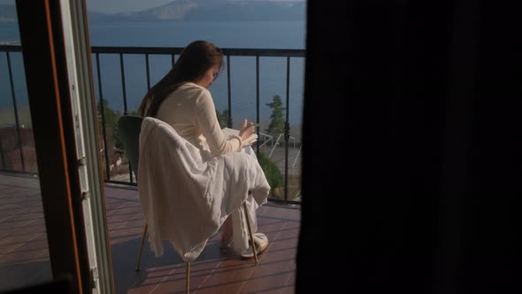 Girl Relaxing with Sketching at the Balcony