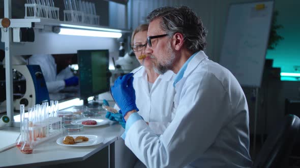 Mature Scientists Trying Samples of Cell Based Meat