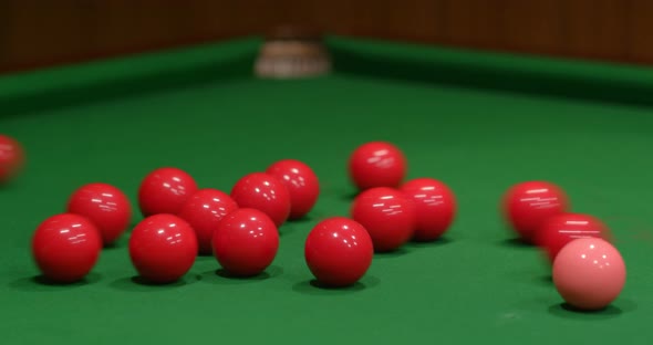 Player shooting snooker ball on table