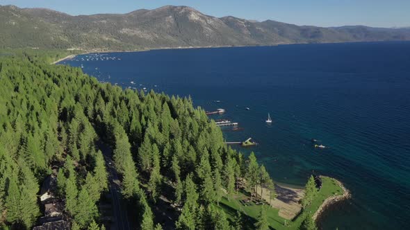 Evergreen Forest With Jetty On The Edge Of Lake Tahoe In Sierra Nevada Mountains, USA. - aerial