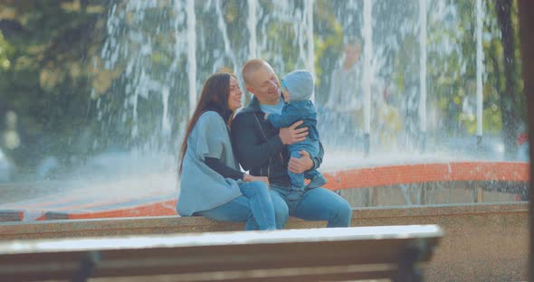 Happy Family Sitting on the Fountain Border