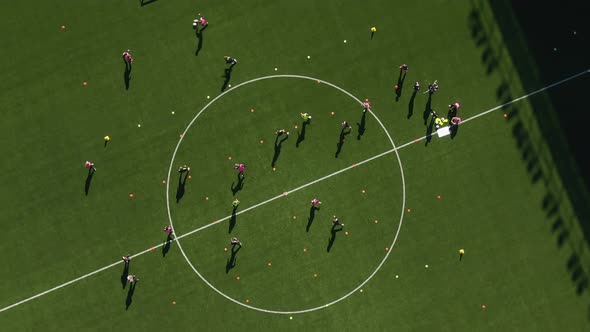 Professional soccer players training at Studenternas Uppsala stadium in Sweden. Aerial top-down orbi