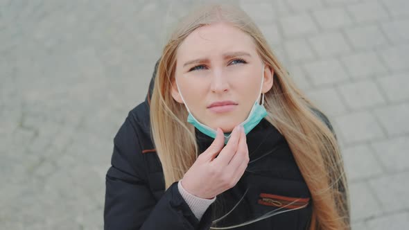 Woman Looking Into the Sky and Putting on Medical Mask.