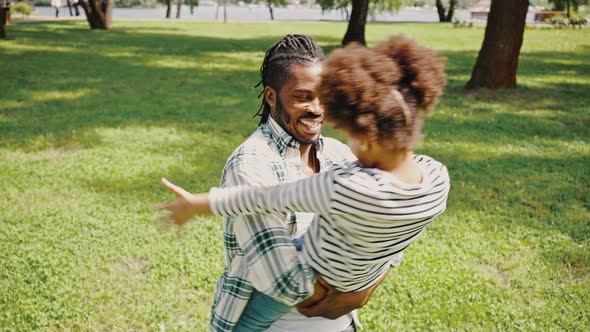 Close Portrait of a Darkskinned Family Father and Daughter Have Fun in the Park