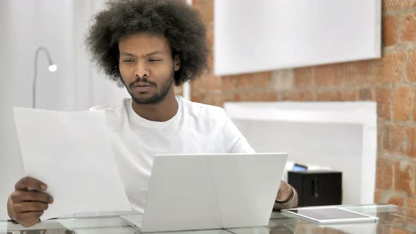 Pensive African Man Reading Documents