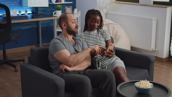 Young Interracial Couple Looking at Smartphone