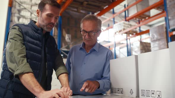 Two caucasian man work in the warehouse. Shot with RED helium camera in 8K.