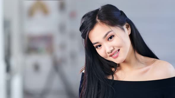 Medium Closeup Portrait of Beautiful Asian Young Girl Smiling Posing and Looking at Camera