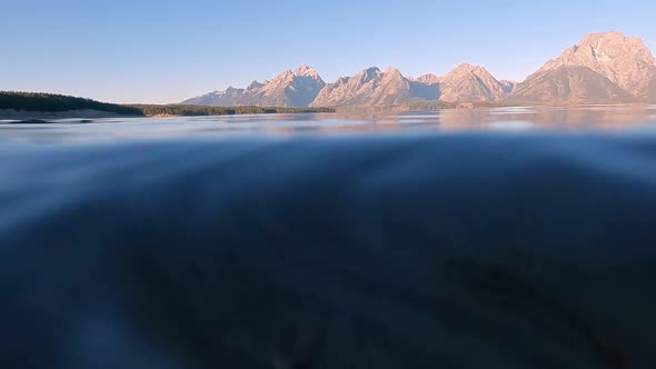 Panning view of the Grand Tetons then moving underwater in Jackson Lake