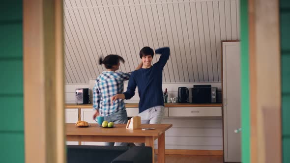 Happy Young People Girl and Her Joyful Boyfriend Are Dancing in Kitchen Hugging