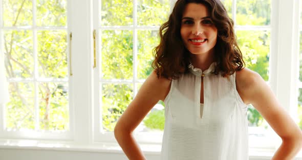 Portrait of smiling beautiful woman standing with arms crossed