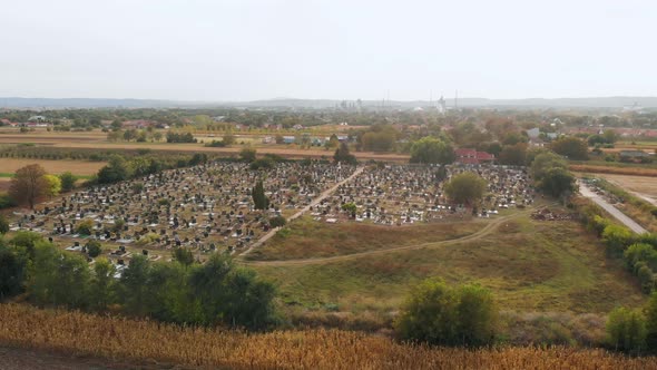 Aerial drone footage of the cemetery by the village. The sunny day above local village cemetery. alt