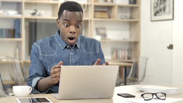 Awful AfroAmerican Man in Shock Working on Laptop