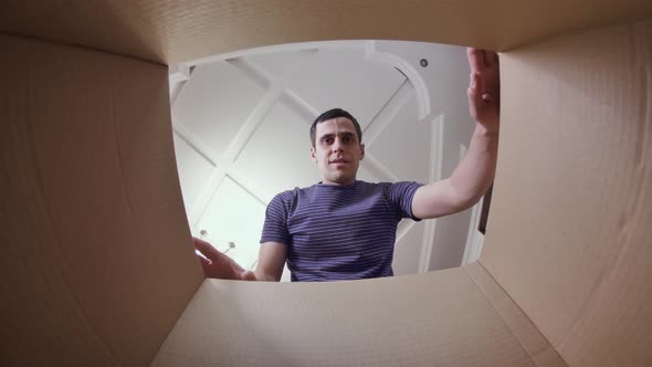 Unhappy Man Opening Cardboard Box