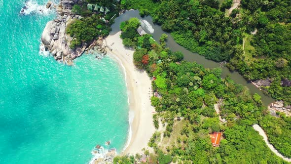 Aerial drone shot landscape of idyllic seashore beach lifestyle by turquoise ocean with white sand b