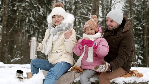 Family Drinking Tea Outdoors in Winter