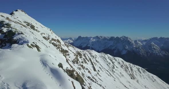 Aerial drone view of snow covered mountains in the winter.